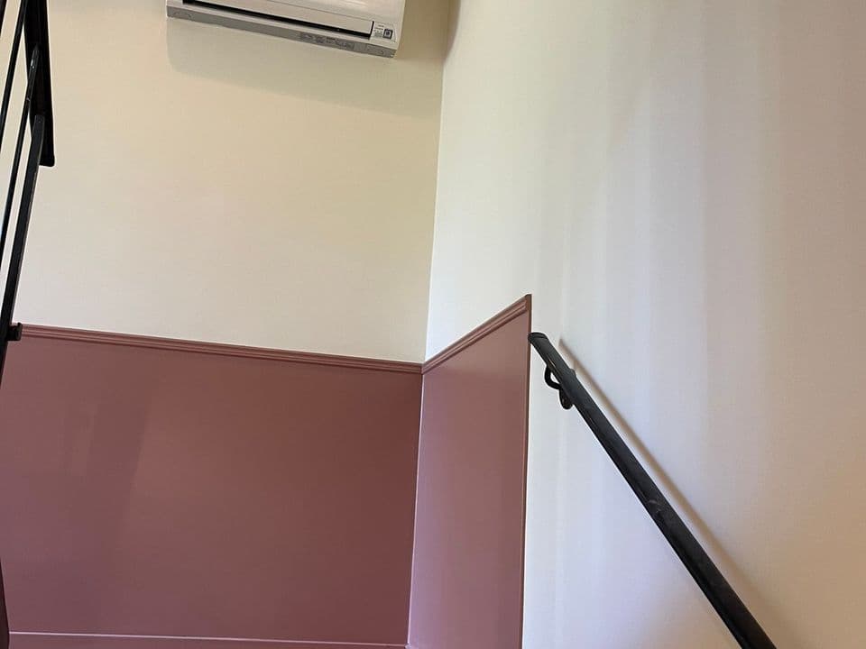 Trapphus med mörkrosa nederdel och ljus vägg ovanför